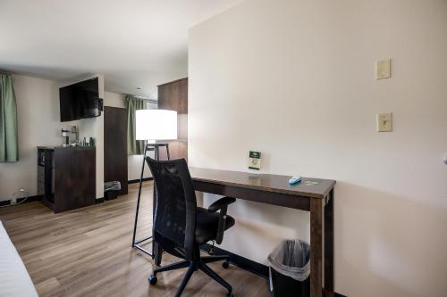a room with a desk with a chair and a lamp at Mountain Vista Hotel in West Yellowstone
