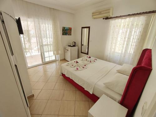 a bedroom with a white bed with flowers on it at Bucak Apart Hotel Göcek & Beach in Göcek