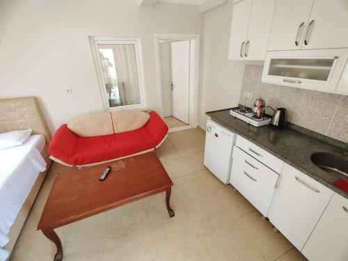 a kitchen with a red chair and a table at Bucak Apart Hotel Göcek & Beach in Göcek