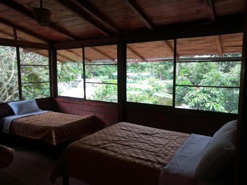 a bedroom with two beds in a room with windows at Pungara Eco-Lodge in Tena