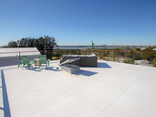 a patio with two chairs and a couch on a roof at Anastasia Island Villa Upper Level plus Rooftop in St. Augustine