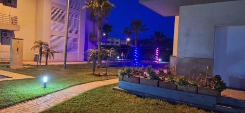 un jardín fuera de un edificio por la noche en Sable d or saidia, en Saidia 