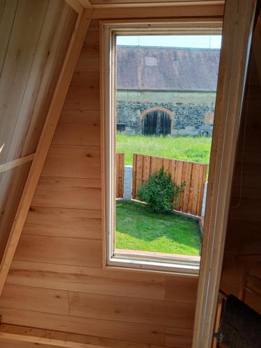 a window in a cabin with a view of a barn at Zittau - Ferienwohnung Frieda mit Camping Familien, und Biker Hütten am Zittauer Gebirge in Zittau