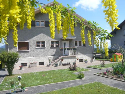 una casa con flores amarillas delante de ella en La Sapotine, en Étrembières