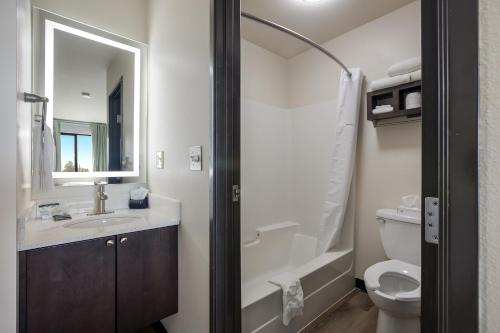 a bathroom with a sink and a toilet and a mirror at Mountain Vista Hotel in West Yellowstone