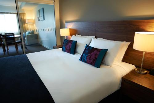 a bedroom with a large white bed with two pillows at Quest Dubbo in Dubbo