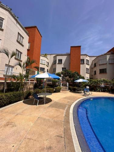 a swimming pool with two umbrellas and a hotel at Apartamento de 2 habitaciones in Pampatar