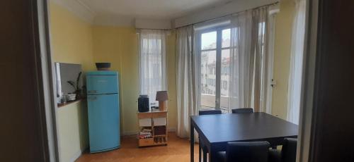 une salle à manger avec un réfrigérateur bleu et une table dans l'établissement Palais Clemenceau, à Nice