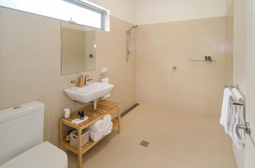 a bathroom with a sink and a toilet and a mirror at Margaret River Beach Studios in Margaret River Town
