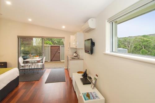 a living room with a large window and a kitchen at Margaret River Beach Studios in Margaret River Town