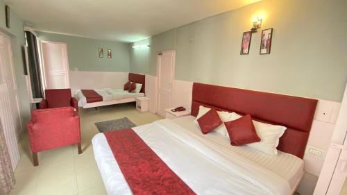 a bedroom with a large bed with red pillows at Ocean Inn & Meadows Inn ! Couple Friendly ! Family Hotel ! Walking Distance From Mall Road in Manāli