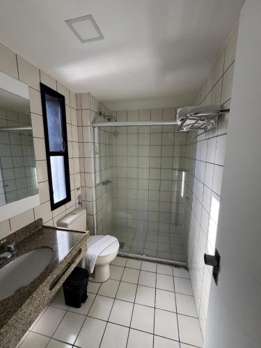 a bathroom with a toilet and a sink and a shower at Praia Mansa Suite Hotel Flat in Fortaleza