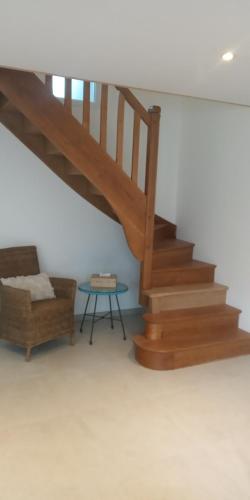 un escalier avec un canapé et une table dans une pièce dans l'établissement la maison bleue, à La Haye-du-Puits