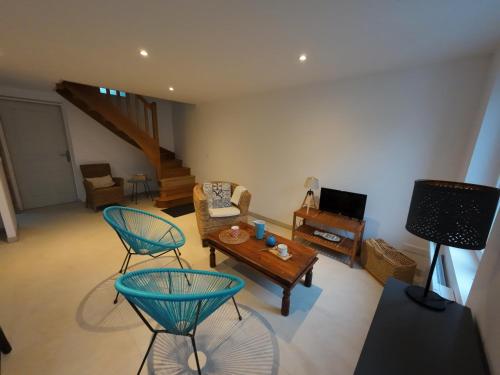 un salon avec deux chaises et une table dans l'établissement la maison bleue, à La Haye-du-Puits