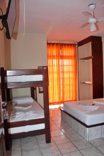 two bunk beds in a room with a window at USCEESP Praia Grande in Praia Grande