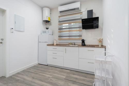 a kitchen with white cabinets and a refrigerator at Resort Circuito Sevilla in Carmona