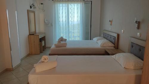 une chambre avec deux lits et une fenêtre dans l'établissement Nikolaou Thomas House, à Parga