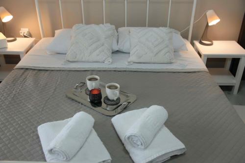 a bed with a tray with towels and two candles at Villa Tzekos in Epanomi
