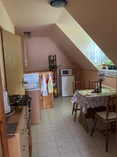 eine Küche mit Tisch und eine Küche mit Treppe in der Unterkunft Lilla Apartman in Sárvár