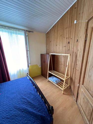 a bedroom with a bed and a wooden wall at Villa Ultima Grigoleti in Lanch'khut'i