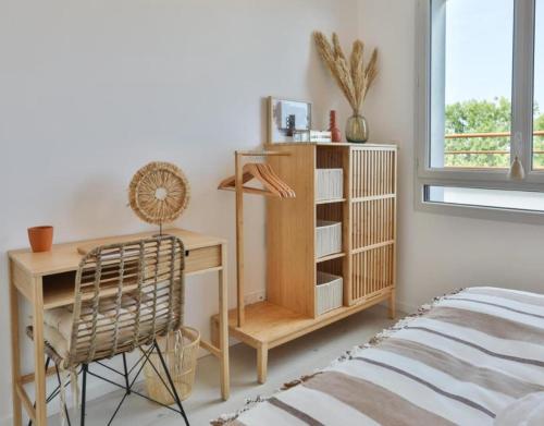 1 dormitorio con escritorio y silla junto a la cama en Appartement cosy 2 ch avec toit terrasse & parking - Lumineux et calme, en Les Sables-dʼOlonne
