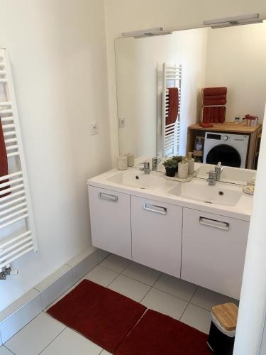 une salle de bain blanche avec un lavabo et un miroir dans l'établissement Appartement cosy 2 ch avec toit terrasse & parking - Lumineux et calme, à Les Sables-dʼOlonne