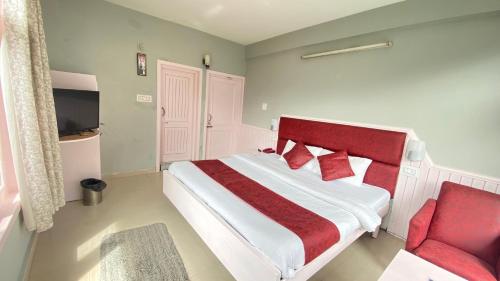 a bedroom with a bed and a red chair at Ocean Dreams & Hotel Meadows Dream ! Bikers,Couple & Family Hotel ! Valley View ! Open Terrace Cafe in Manāli