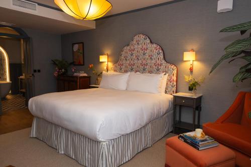 a hotel room with a large bed and a chair at The Hat Maker Boutique Hotel in Dungarvan