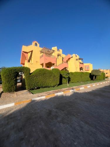 a house with green hedges on the side of a road at Family Holiday 2 Bedroom Chalet with free Beach & Pool in Sharm, Egypt in Sharm El Sheikh