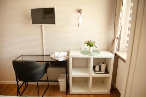 a desk with a chair and a glass table at WohnRaum Gäste- & Boardinghaus in Gusterath
