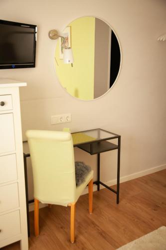 a desk with a chair and a mirror at WohnRaum Gäste- & Boardinghaus in Gusterath