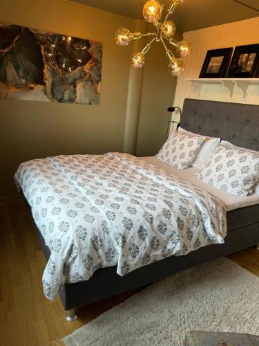 a bedroom with a bed with a comforter on it at Åskollen, Drammen in Drammen