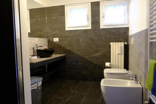 un baño con inodoro y lavabo en Garden Apartment, en San Colombano al Lambro
