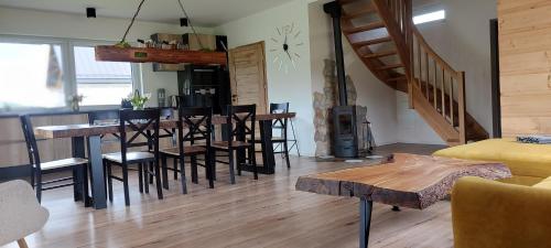 a living room with a bar with chairs and a table at Rajderówka in Krzyżowa