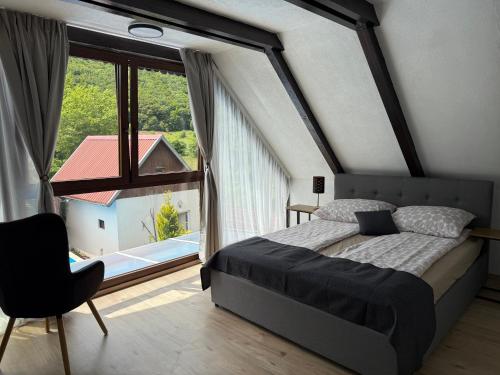 a bedroom with a bed and a large window at Holiday House Vale Verde in Korenica