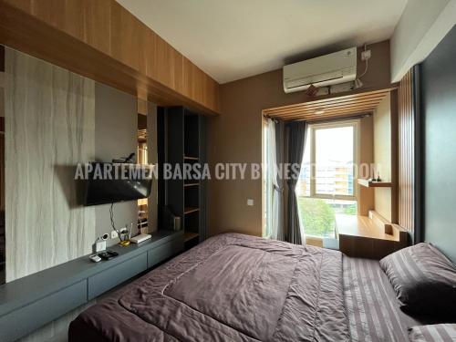 une chambre avec un lit, une télévision et une fenêtre dans l'établissement Apartemen Barsa City ByNestoraroom, à Seturan