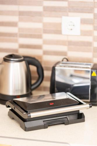 a scale sitting on a counter next to a tea kettle at SeaAuraApartment in Áyioi Apóstoloi