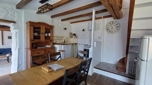 Il comprend une cuisine et une salle à manger avec une table en bois. dans l'établissement Pont Menou Bretagne, à Plouégat-Guérand