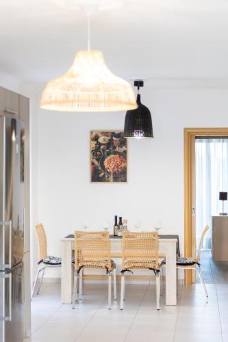a kitchen and dining room with a table and chairs at SeaAuraApartment in Áyioi Apóstoloi