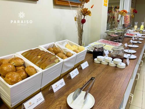 a table with various types of pastries and other foods at Hoteles Paraiso CHICLAYO in Chiclayo