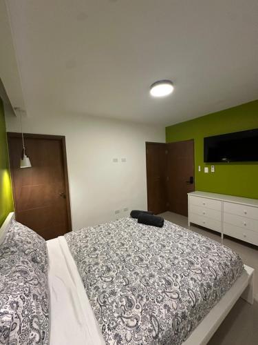 a bedroom with a bed and a flat screen tv at Hermoso apartamento cerca de la playa in La Romana
