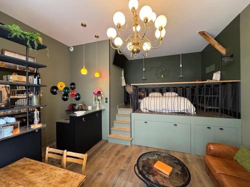 un salon avec un lit et un lustre dans l'établissement My little loft in the heart of the city, à Tours