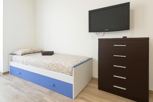 a bedroom with a bed and a tv and a dresser at San Siro ippodromo fiera Milano apartment x4pax in Milan