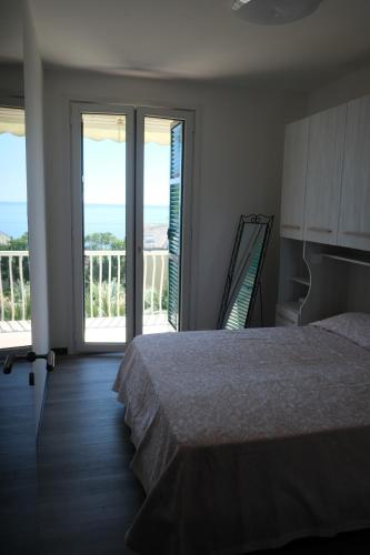 a bedroom with a bed and a balcony with the ocean at Nervi, sea view in Genoa