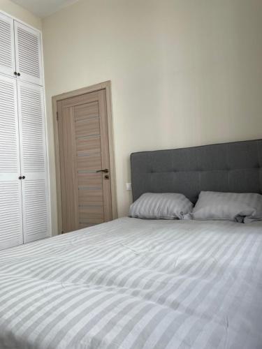 a bedroom with a large bed with white sheets at Pasta apartment Self-Check-in in Liepāja