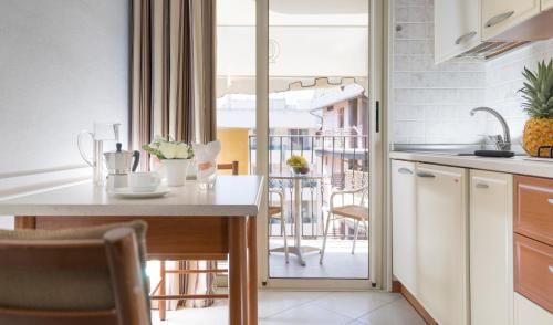 a kitchen with a table and a view of a balcony at Residence Queen in Rimini