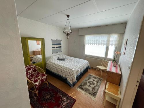 a small bedroom with a bed and a chair at Hiitolantie 4 in Härmä