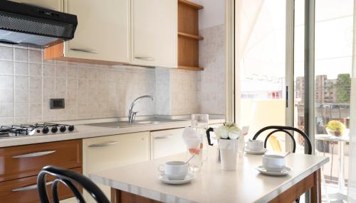 a kitchen with a sink and a table with chairs at Residence Queen in Rimini