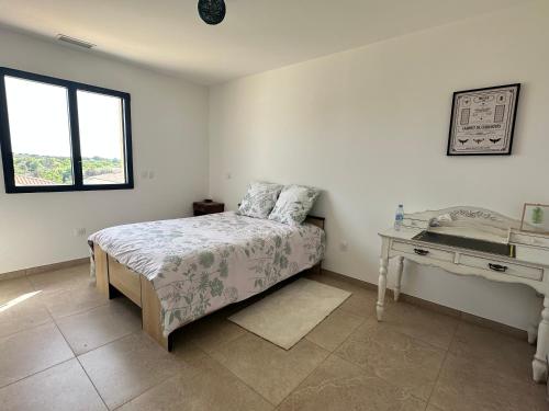une chambre blanche avec un lit et un bureau dans l'établissement Maison familiale avec piscine près de Nimes Calme & confort en Provence, à Saint-Gilles
