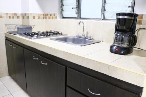 a kitchen counter with a sink and a mixer at Hermoso Apartaestudio, moderno, cercaavdelosestudiantes, apto303 in Pasto